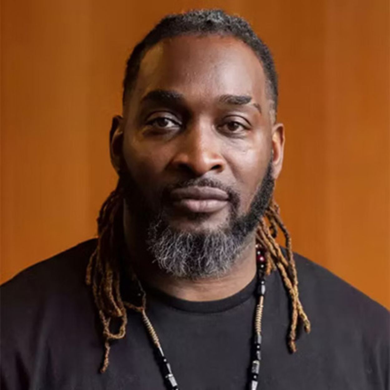 Kenrick Sandy against an orange background